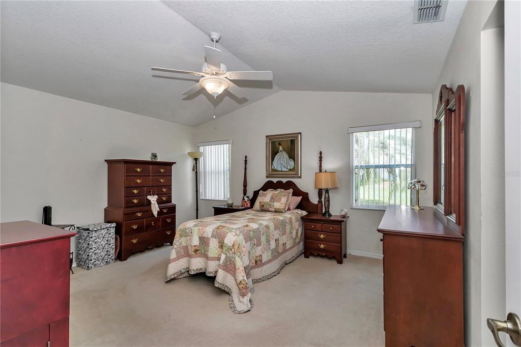 8342 Southwest 65th Avenue Ocala, FL 34476 - Photo 18 of 40 a bedroom with a bed and a chandelier