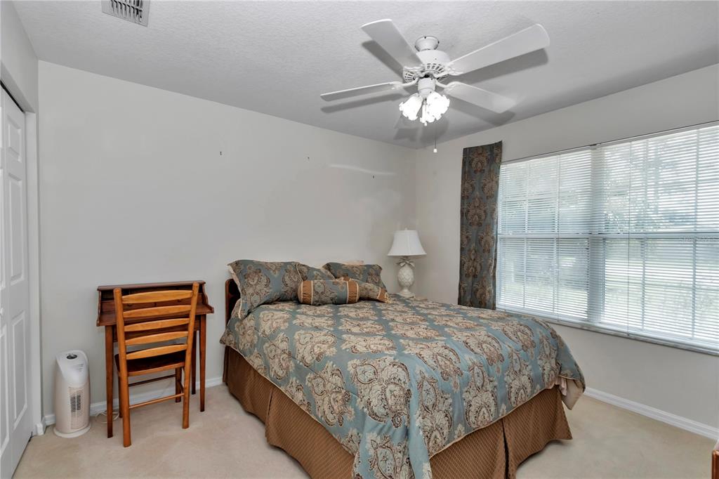 8342 Southwest 65th Avenue Ocala, FL 34476 - Photo 24 of 40 a bedroom with a large bed and a chandelier