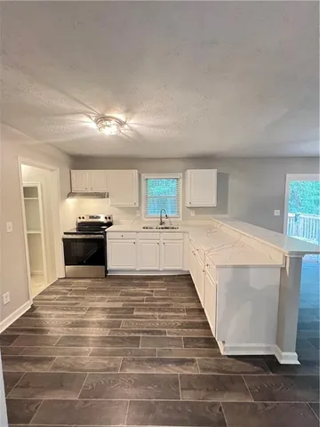 a view of a kitchen with cabinets and wooden floor