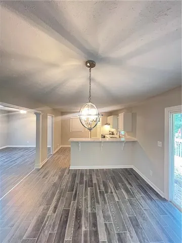 a view of a room with wooden floor air conditioner and windows