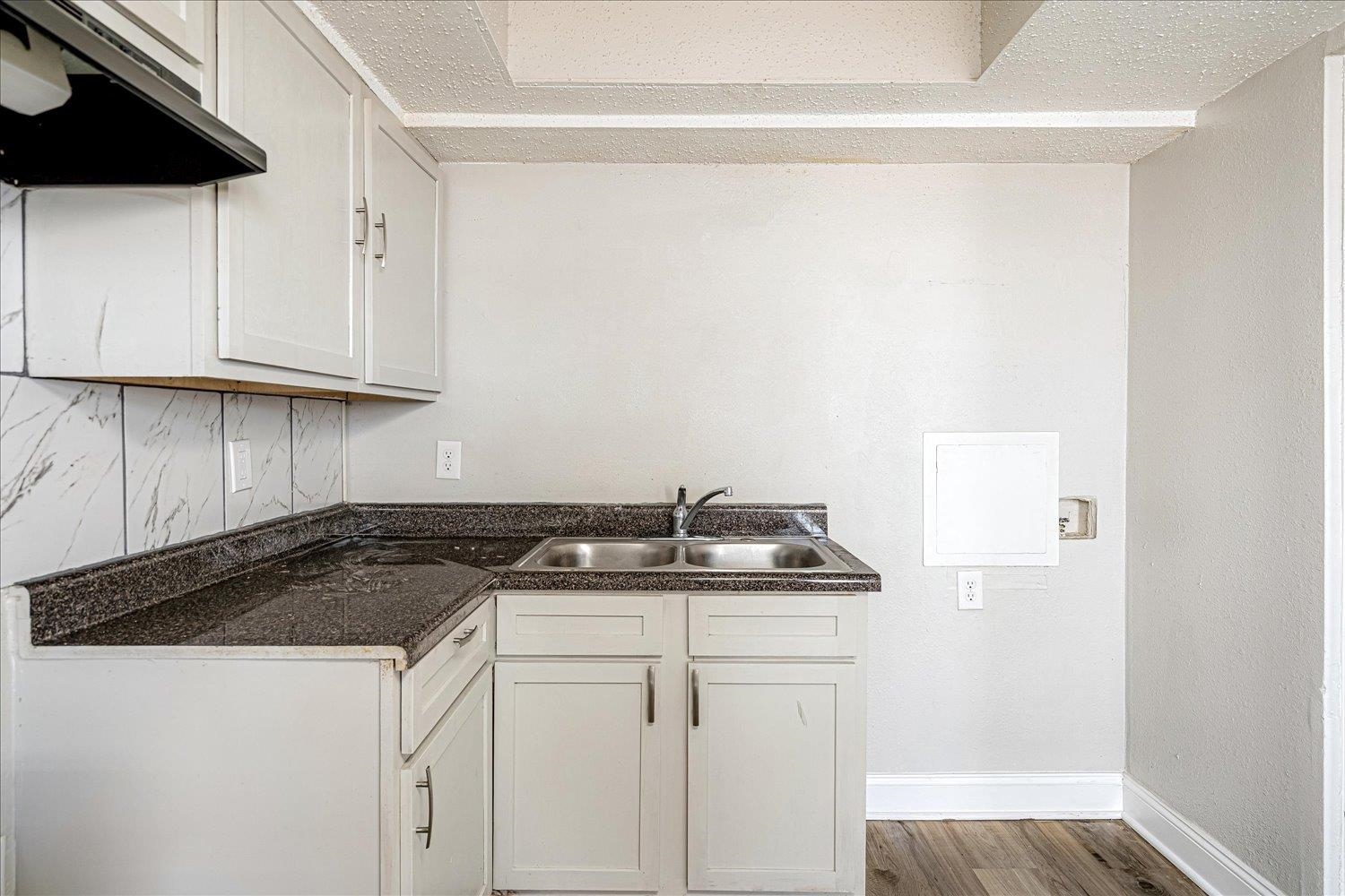 3084 Pershing Avenue Memphis, TN 38112 - Photo 16 of 30 Kitchen featuring range hood, dark wood-type flooring, white cabinets, dark countertops, and a textured ceiling