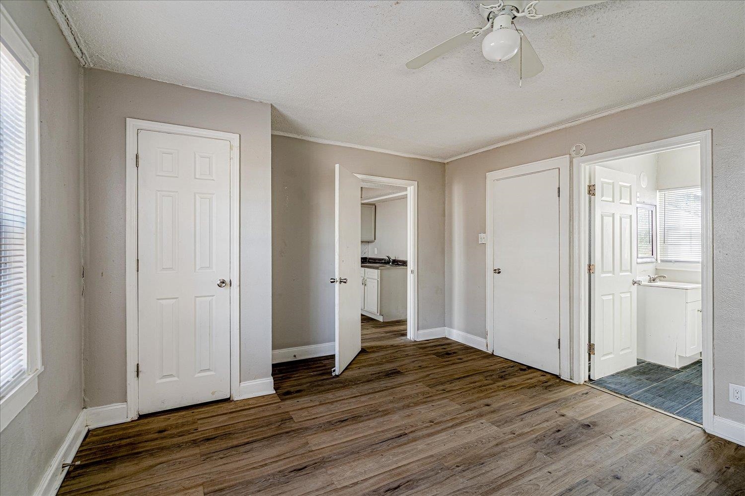 3084 Pershing Avenue Memphis, TN 38112 - Photo 19 of 30 Unfurnished bedroom with a textured ceiling, dark wood-type flooring, a ceiling fan, and ensuite bath