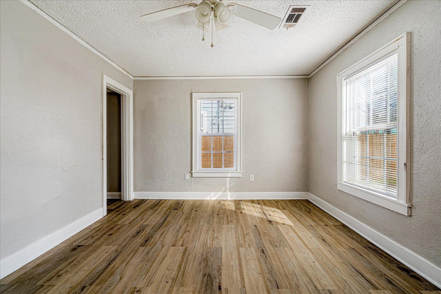 3084 Pershing Avenue Memphis, TN 38112 - Photo 10 of 30 Empty room featuring light wood-style flooring, a textured wall, ceiling fan, a textured ceiling, and ornamental molding