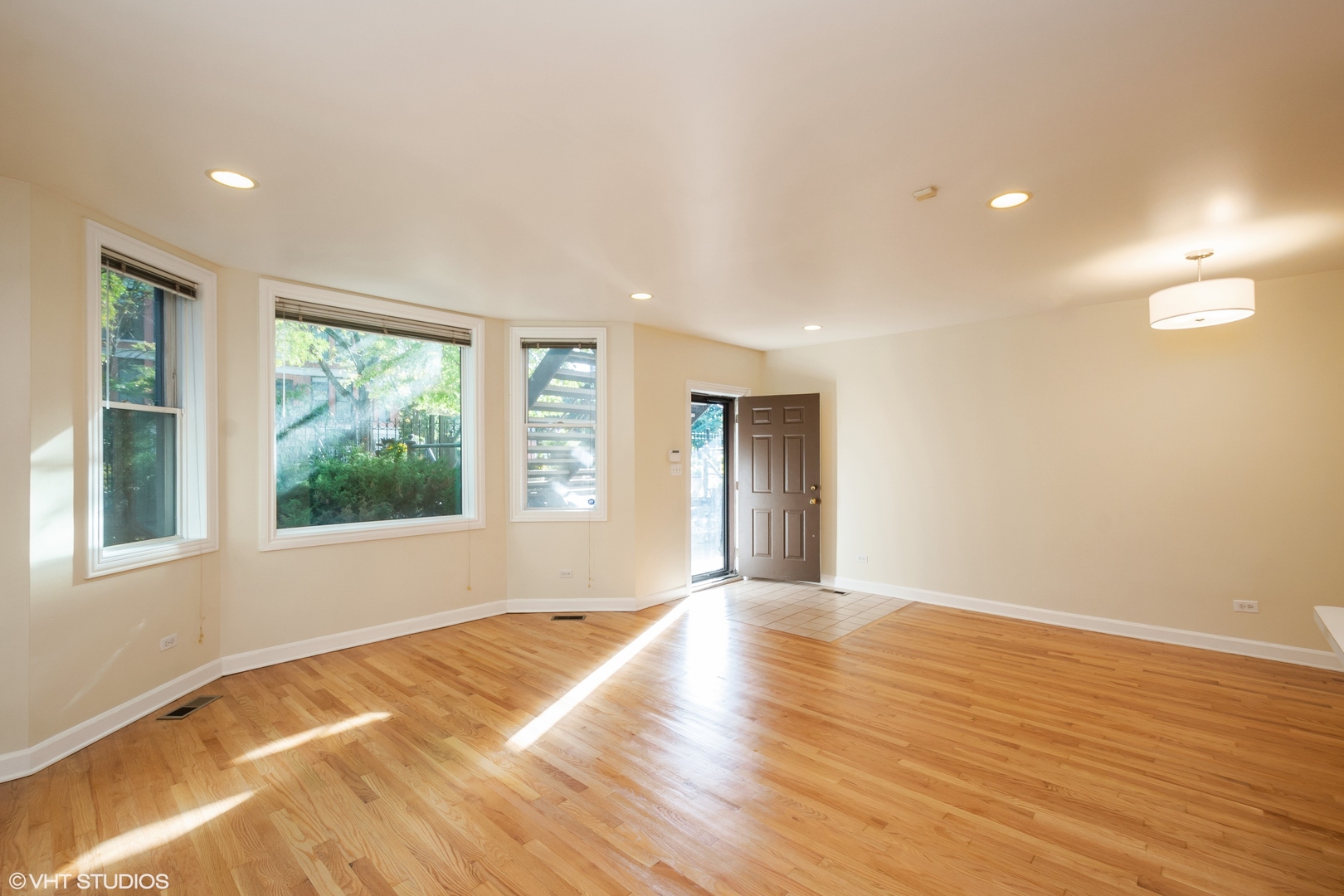 1550 West Jackson Boulevard, Unit 1 Chicago, IL 60607 - Photo 3 of 10 a view of an empty room with wooden floor and a window