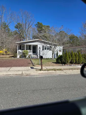 a front view of a house with a yard and palm trees