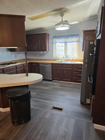 a kitchen with a sink cabinets and wooden floor