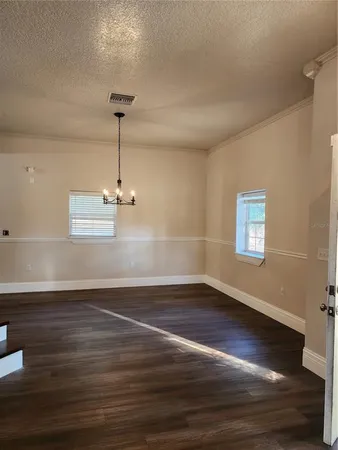 a view of a room with wooden floor and a ceiling fan