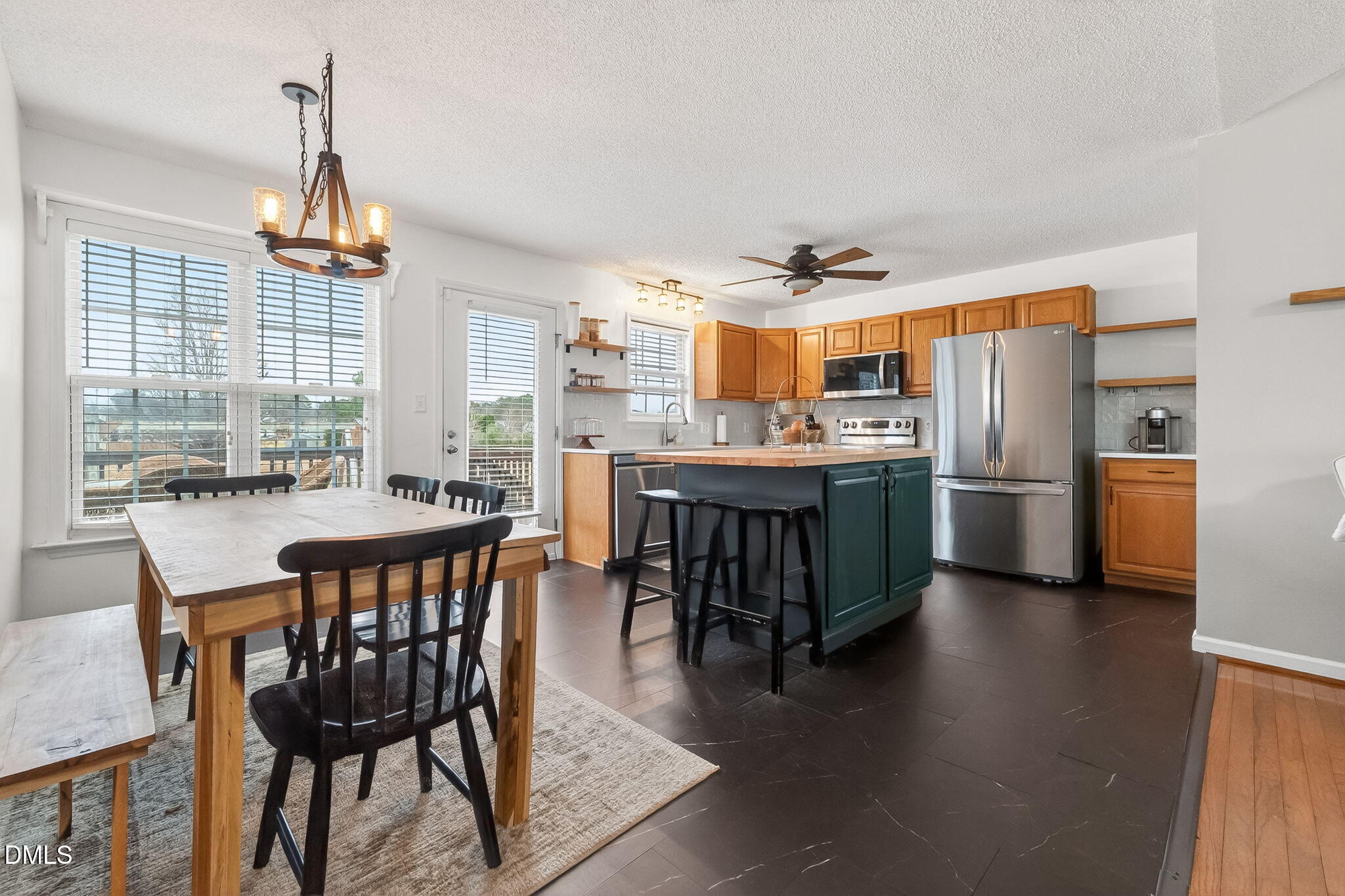 a dining room with stainless steel appliances a table and chairs