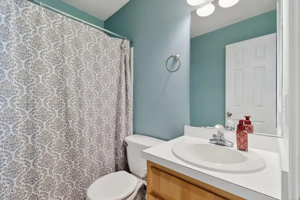 a bathroom with a sink a toilet and a mirror