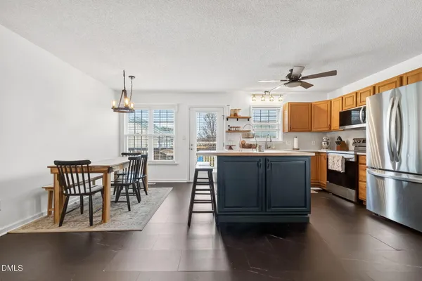 a kitchen with a table chairs refrigerator and cabinets