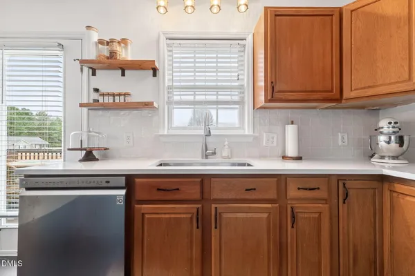 a kitchen with stainless steel appliances granite countertop a sink and cabinets with wooden floor