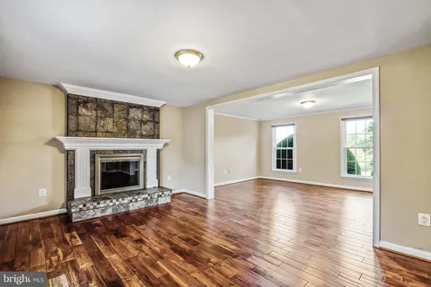 a view of a livingroom with wooden floor and a fireplace