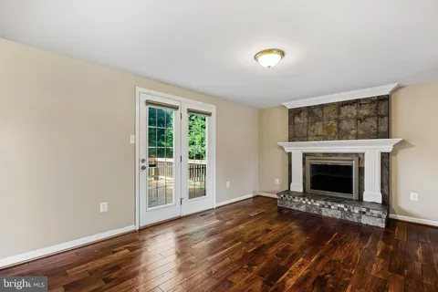 a view of a livingroom with wooden floor and a fireplace