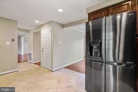 a view of a hallway with stainless steel appliances a refrigerator and window