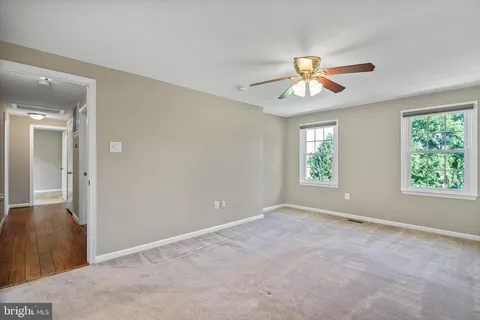 a view of an empty room with a ceiling fan and a window