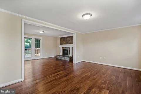 an empty room with wooden floor and fireplace