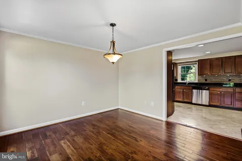 a view of a room with wooden floor chandeliers and a window