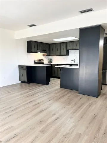 a kitchen with stainless steel appliances kitchen island sink refrigerator and stove