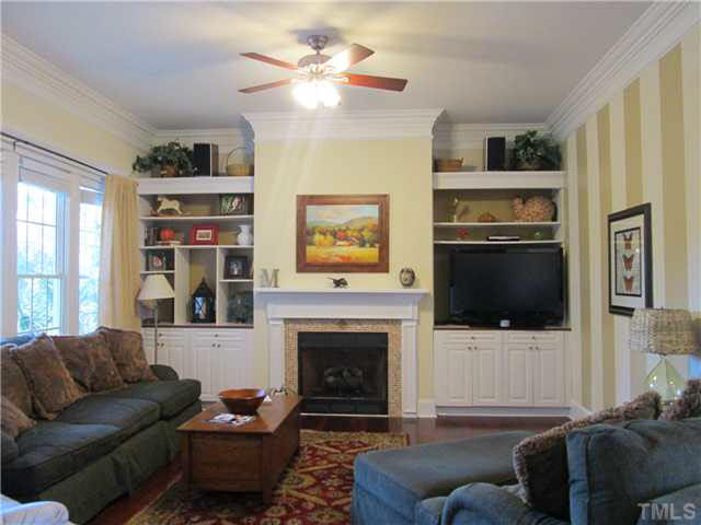 5 Chasewood Court Durham, NC 27703 - Photo 7 of 25 a living room with furniture a flat screen tv and a fireplace