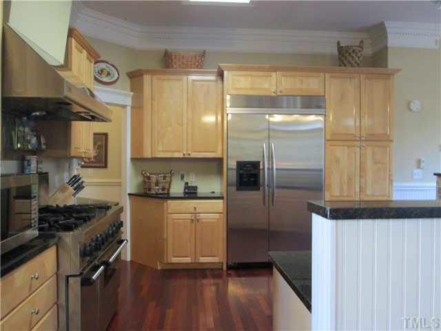 5 Chasewood Court Durham, NC 27703 - Photo 10 of 25 a kitchen with stainless steel appliances a refrigerator a sink and wooden cabinets