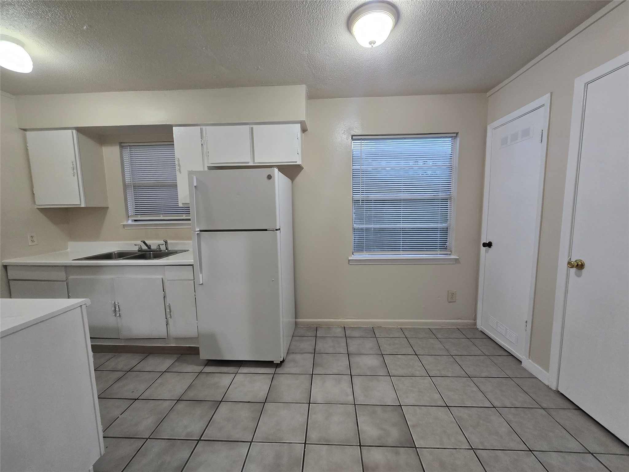 3714 Ave South, Unit 7 Galveston, TX 77550 - Photo 5 of 8 a kitchen with a refrigerator a stove top oven and cabinets