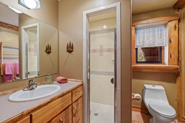 a bathroom with a sink toilet a mirror and shower