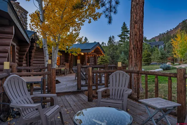 a view of a patio with couches table and chairs and wooden fence