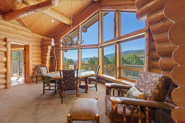 a dining room with furniture water view and large windows