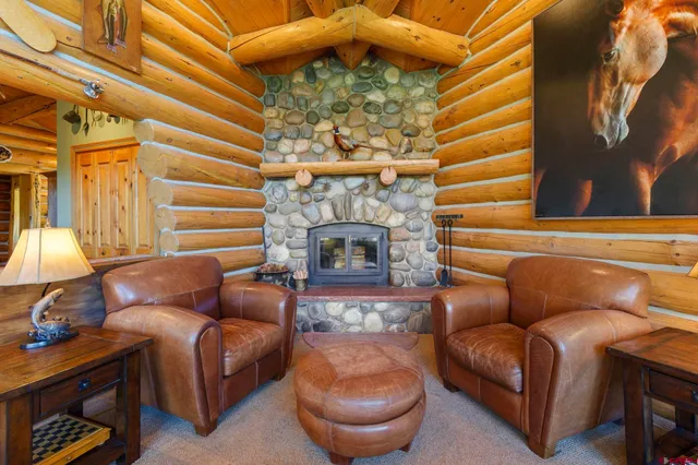 a living room with furniture a fireplace and a chandelier
