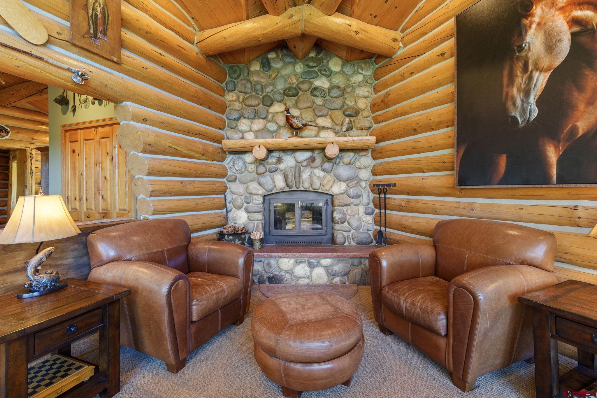 114 Rimrock Drive Durango, CO 81301 - Photo 5 of 42 a living room with furniture a fireplace and a chandelier