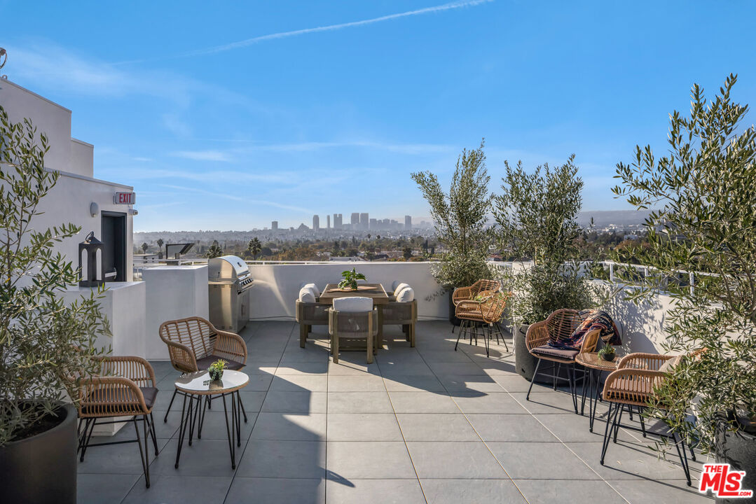 1110 South Spaulding Avenue, Unit 102 Los Angeles, CA 90019 - Photo 11 of 13 a terrace with outdoor seating and city view