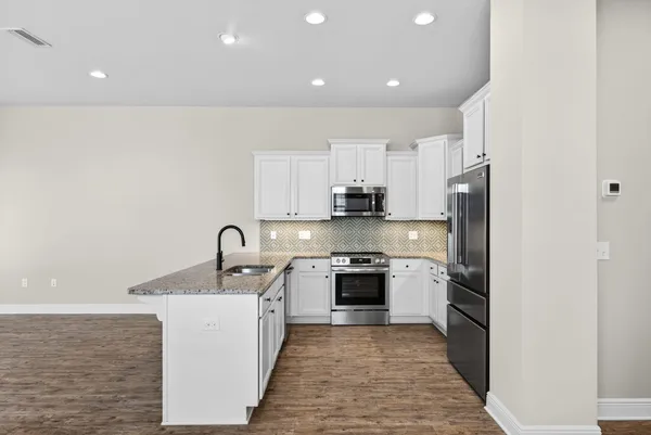 a kitchen with stainless steel appliances granite countertop a sink stove and refrigerator