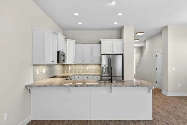 a kitchen with kitchen island granite countertop a stove a sink and a refrigerator