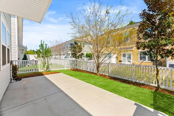 a view of a house with a small yard and a large tree
