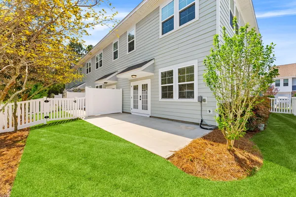 a view of a house with backyard and a tree