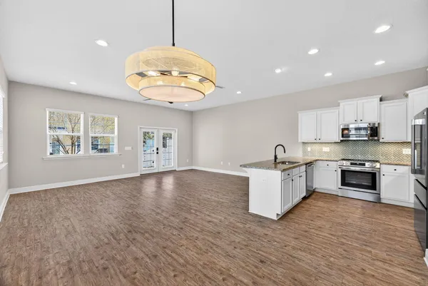 a kitchen with granite countertop a stove and a wooden floor
