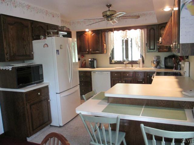 317 Filetown Road Nazareth, PA 18064 - Photo 13 of 37 a kitchen with kitchen island a stove a refrigerator and a dining table with wooden floor