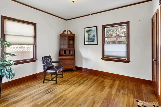 a view of a hallway with wooden floor and a bathroom
