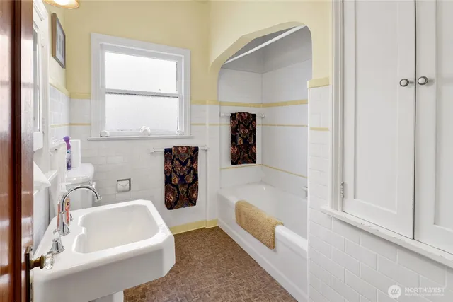 a living room with chair a rug and a window