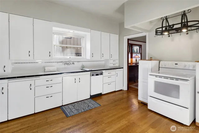a kitchen with granite countertop white cabinets and white appliances
