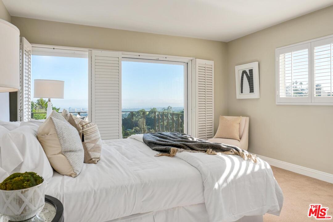 11284 Chalon Road Los Angeles, CA 90049 - Photo 8 of 14 a bedroom with a bed and wooden floor