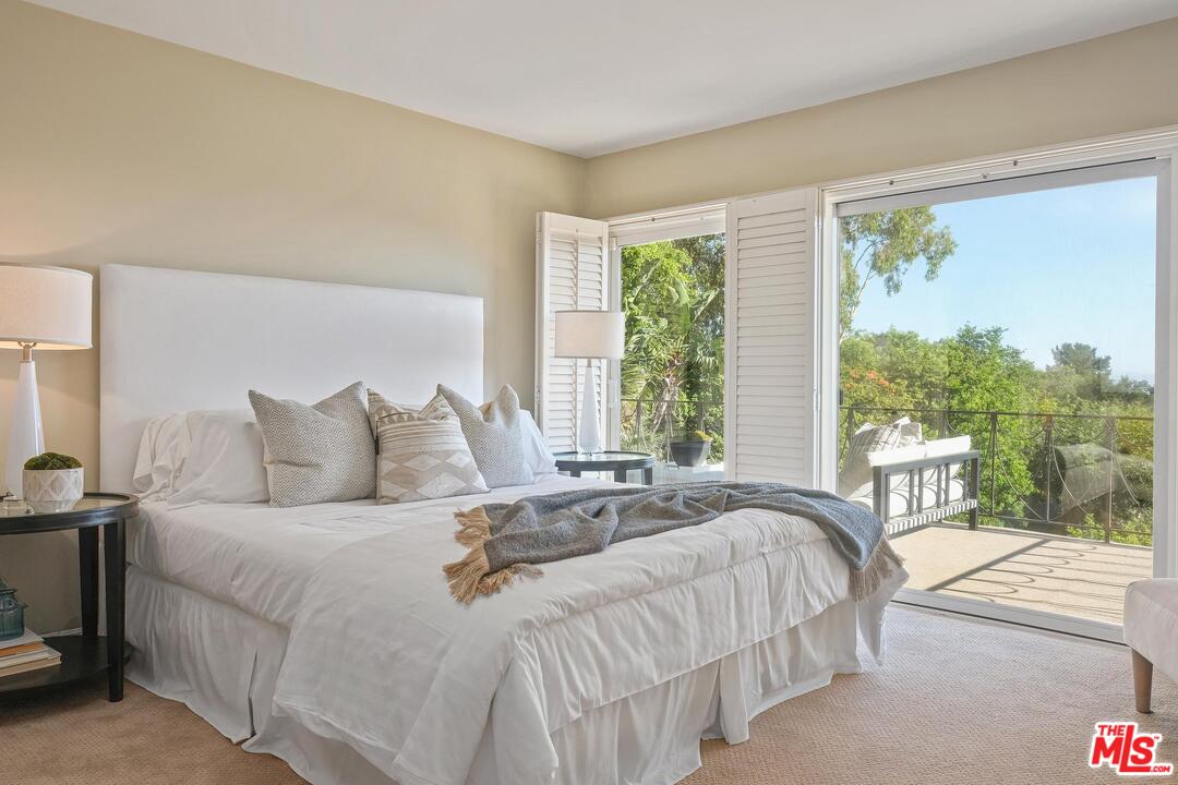 11284 Chalon Road Los Angeles, CA 90049 - Photo 9 of 14 a bedroom with a bed and a large window