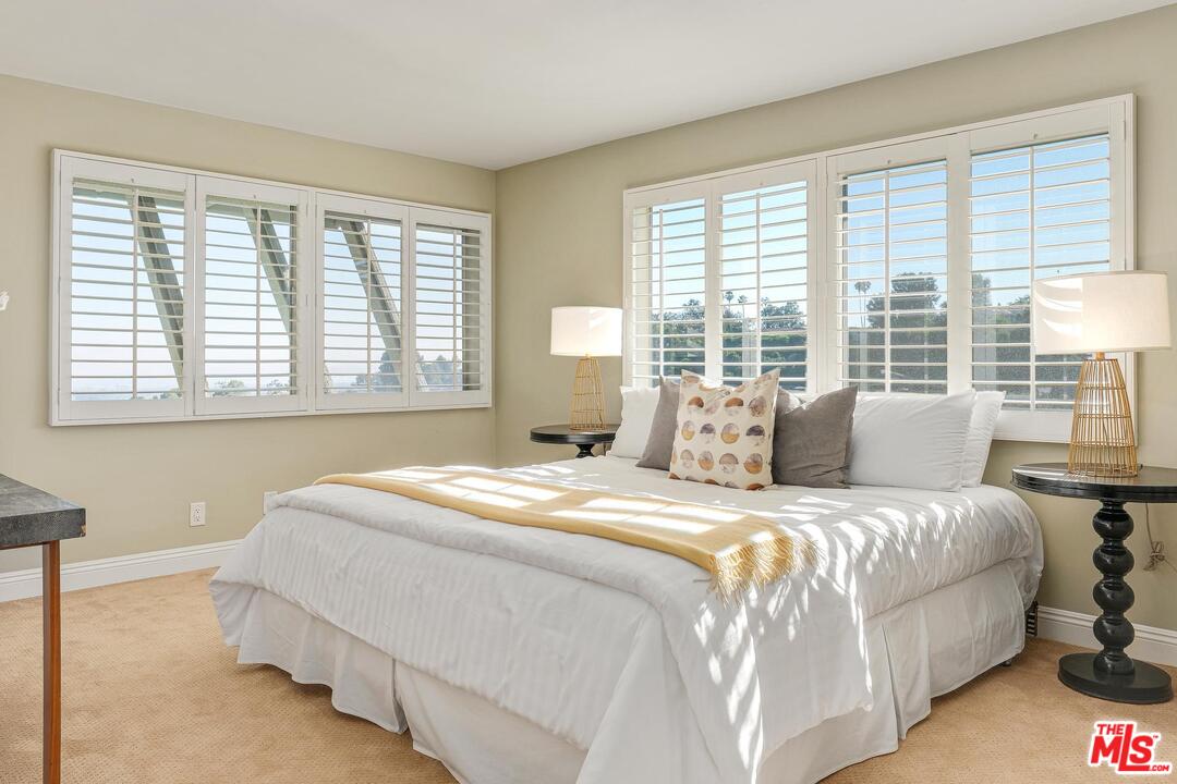 11284 Chalon Road Los Angeles, CA 90049 - Photo 10 of 14 a bedroom with a bed and a large window