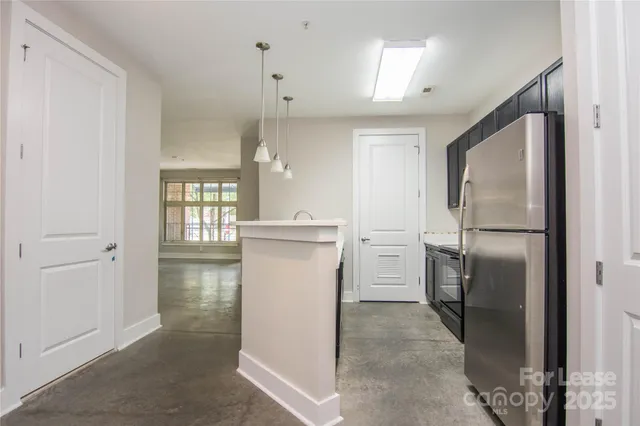 a kitchen with a refrigerator sink and cabinets