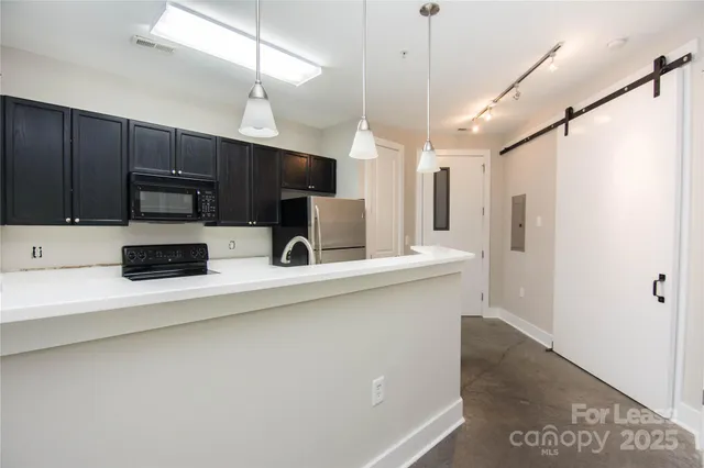 a kitchen with stainless steel appliances a refrigerator sink and microwave
