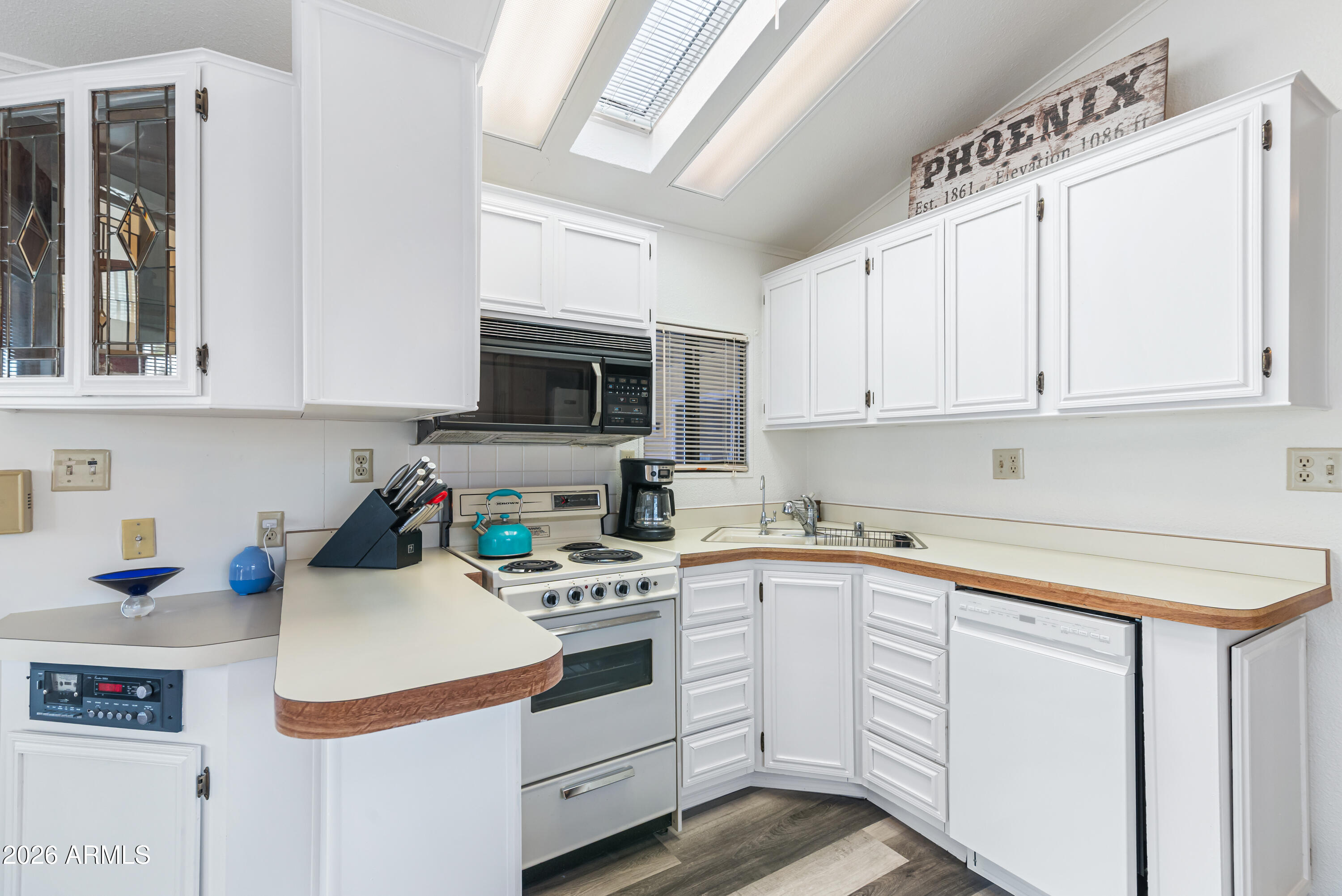 111 South Greenfield Road, Unit 547 Mesa, AZ 85206 - Photo 12 of 38 a kitchen with white cabinets and white appliances