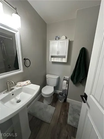 a bathroom with a toilet sink and mirror