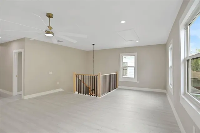 an empty room with fan and windows