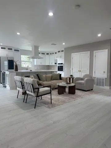 a spacious bedroom with a bed a chandelier and a window