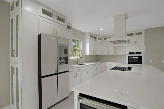 a kitchen with kitchen island granite countertop a stove sink and cabinets